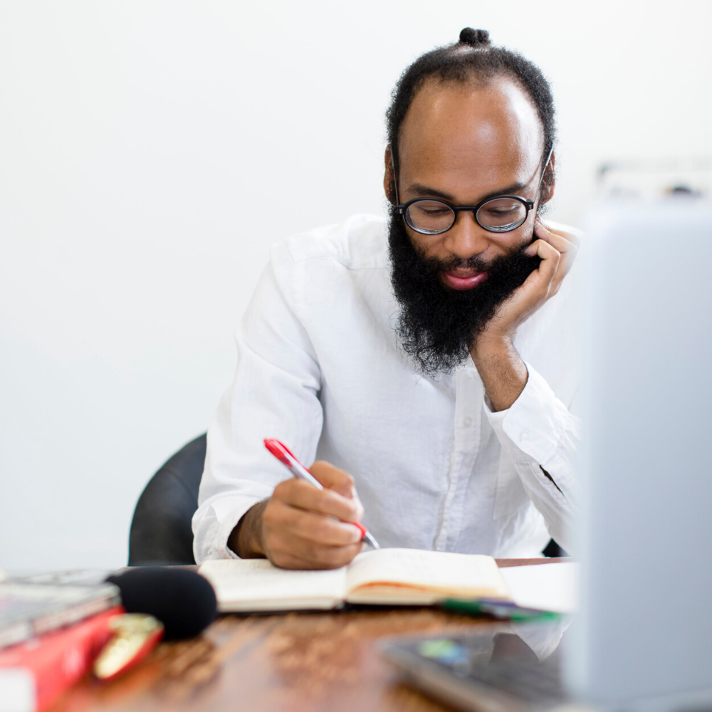 man sitting at desk in white shirt